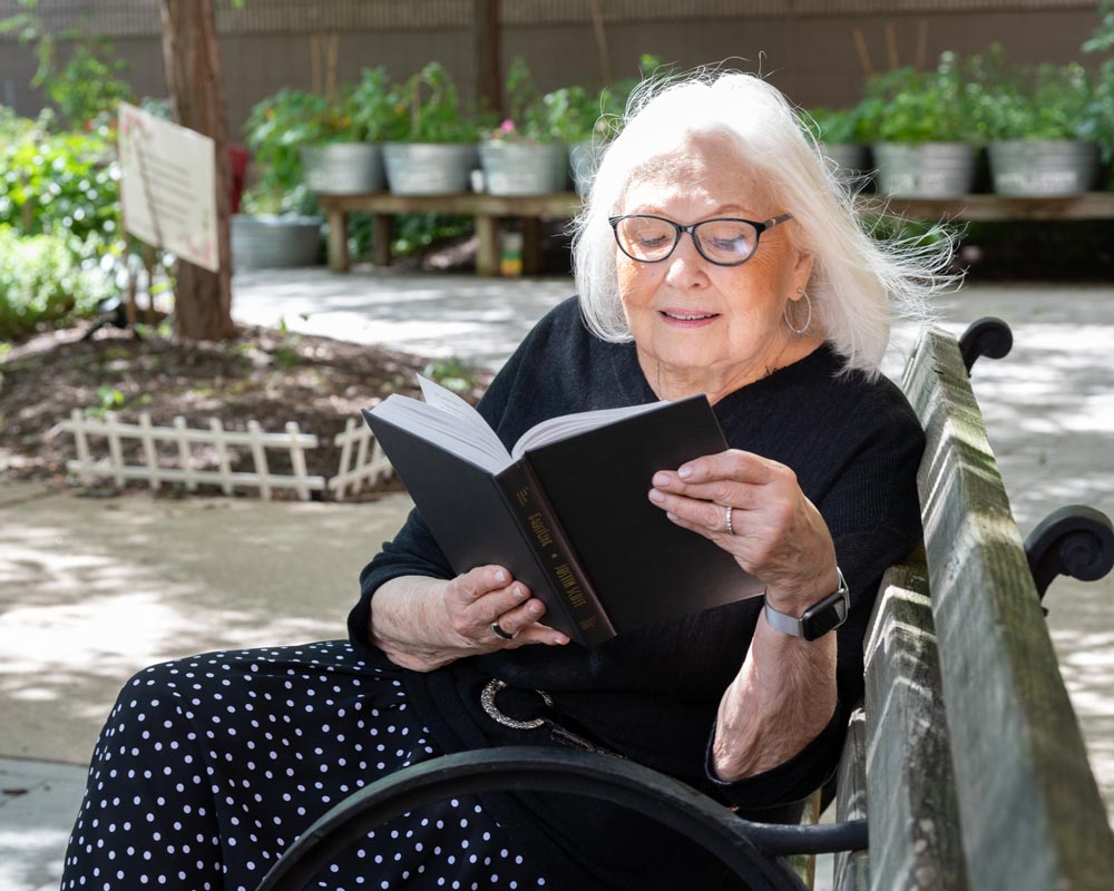 Senior Jewish woman reading a book outside